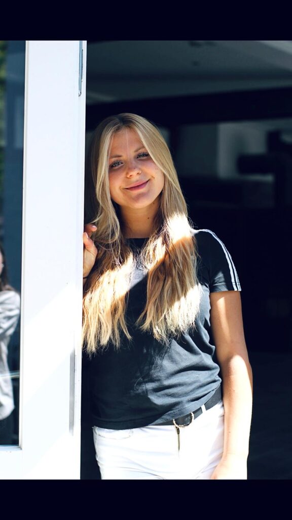 hübsches Mädchen steht an der Tür und lächelt